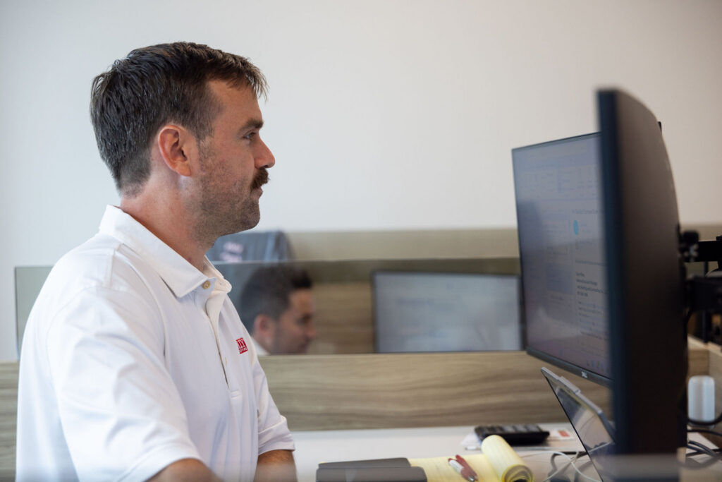 Man working at the computer for a roofing company.